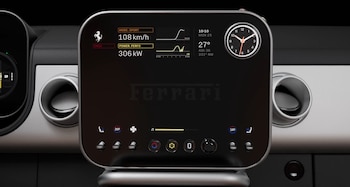 Pantalla digital central de un Ferrari mostrando velocidad, potencia, modo deportivo y un reloj analógico, con botones de control