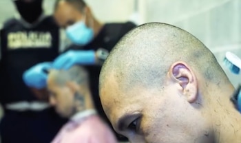 Los reclusos trasladados al CACCO aparecieron con la cabeza rapada y uniformes naranja durante el procedimiento de ingreso al complejo penitenciario. Crédito: Ministerio de Justicia y Paz