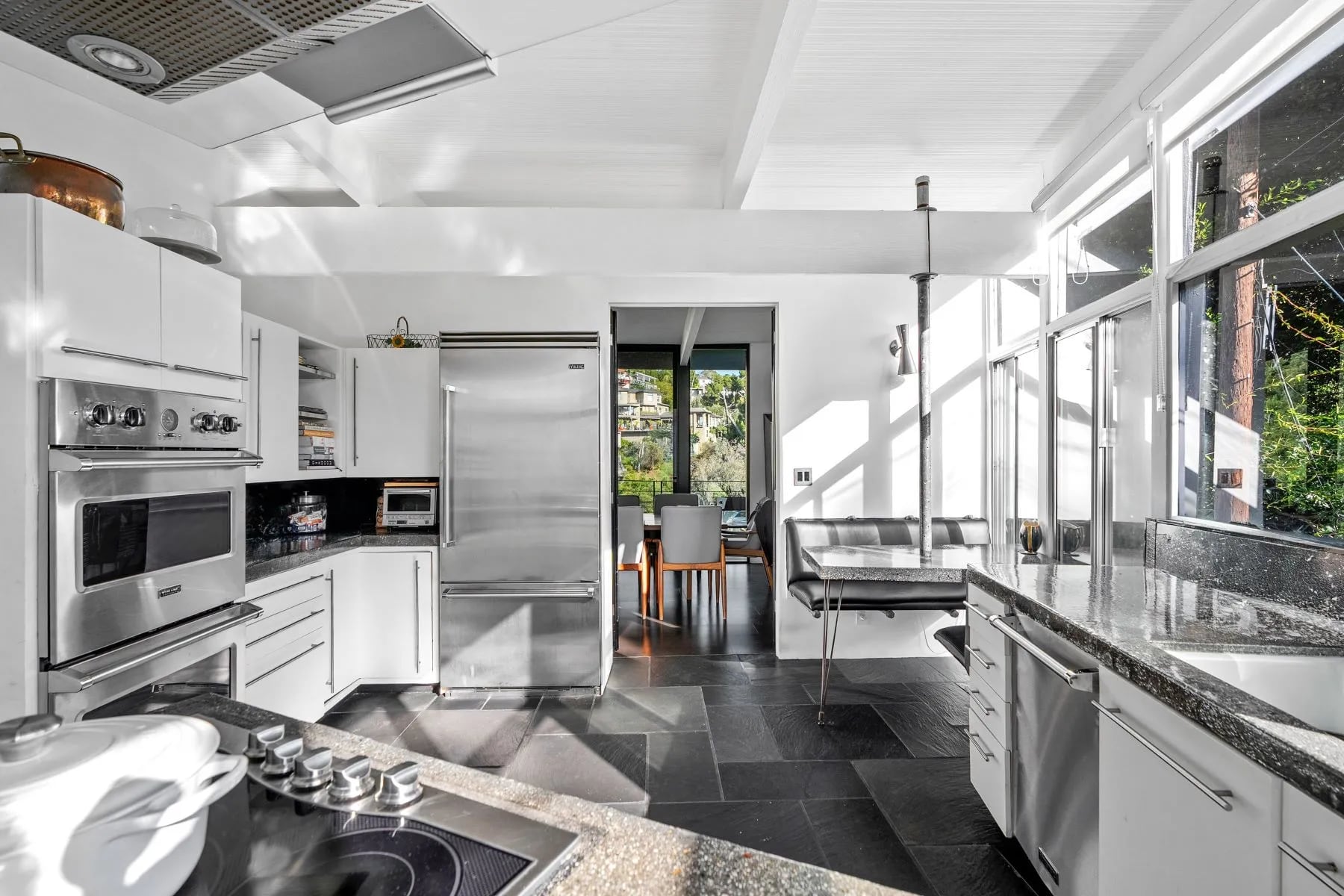La cocina de la propiedad ha sido completamente renovada y presenta un diseño contemporáneo en tonos blancos, equipado con electrodomésticos modernos y superficies de trabajo extensas. Foto: sothebysrealty.com