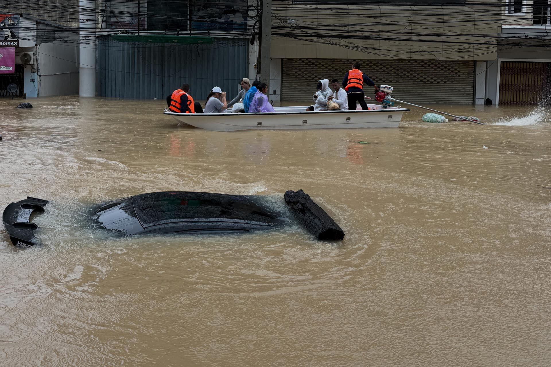 Un equipo de rescate tailandés en un bote pasa junto a un automóvil sumergido en las aguas de la inundación en la provincia de Songkhla, en el sur de Tailandia, el lunes 24 de noviembre de 2025. (Foto AP)