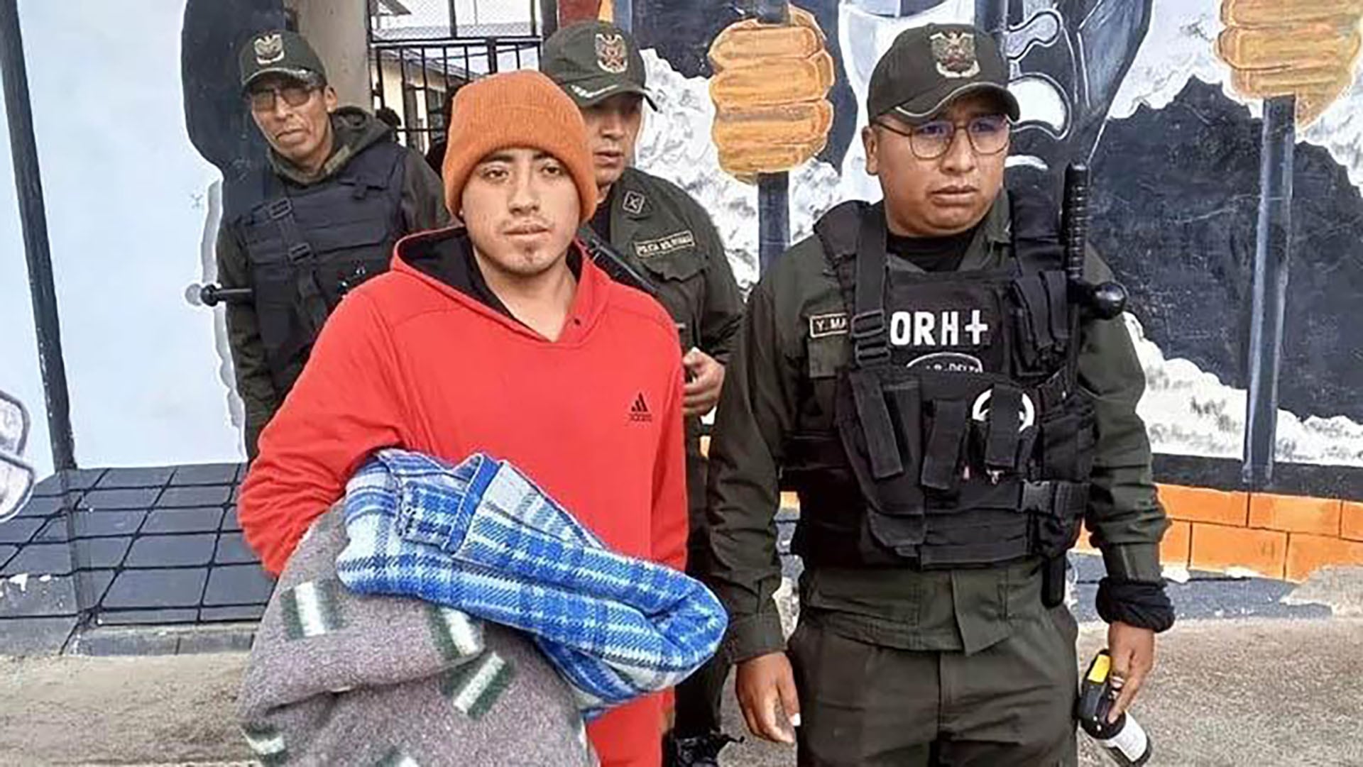 Joel Pérez, acusado en el caso de la desaparición de Odalys Vaquiata, es escoltado por agentes de la policía boliviana al inicio del juicio.