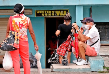 Varias personas esperan fuera de