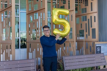 Fotografía divulgada por el Distrito de Escuelas Secundarias Phoenix Union donde aparece Joseph Parra Miguel, de 18 años e hijo de inmigrantes mexicanos, sosteniendo un globo en forma del número cinco en alusión a su logro de 5 millones de dólares en becas. EFE/ Distrito de Escuelas Secundarias Phoenix Union