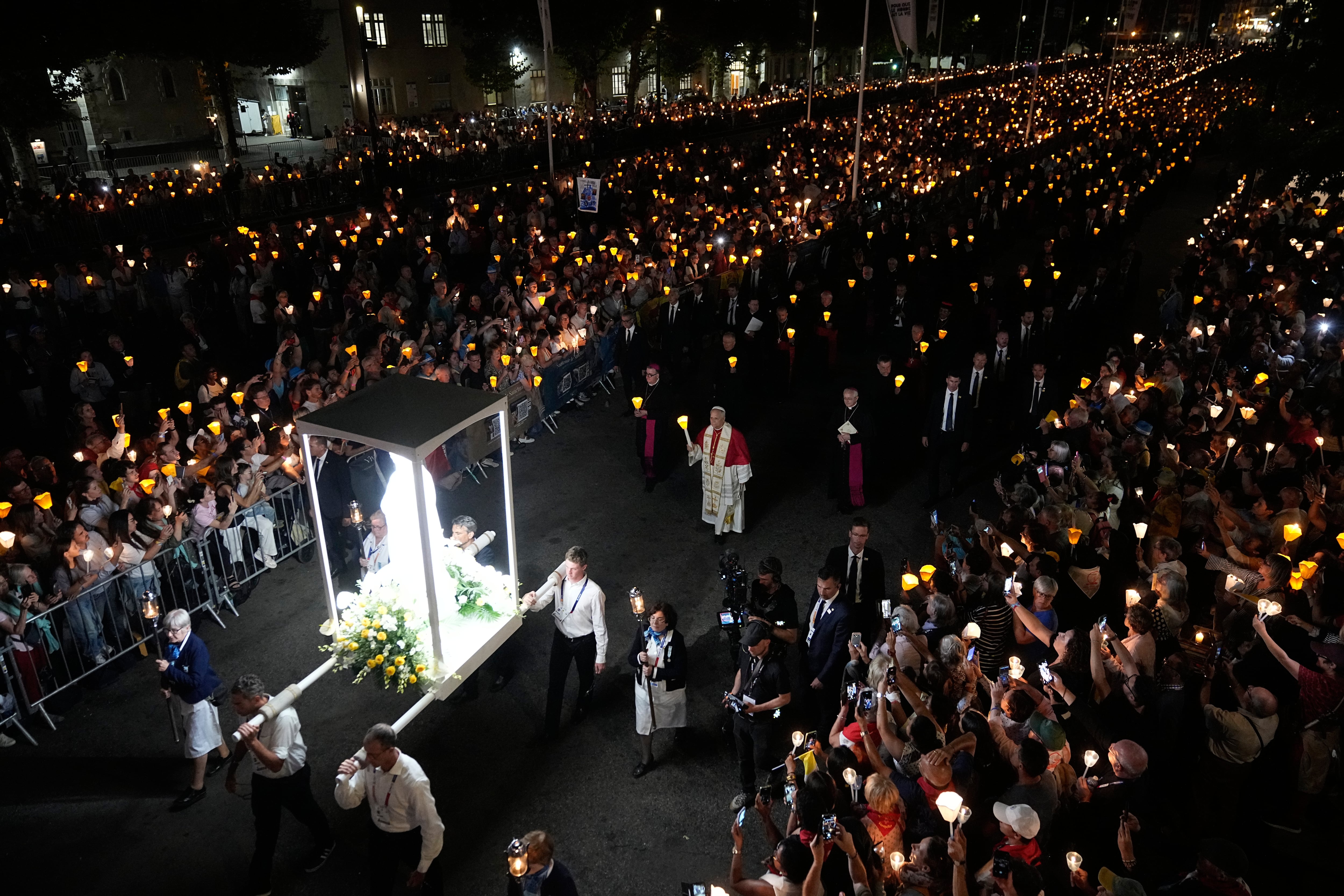 El Papa León XIV, centro, sostiene una vela durante el rezo del Santo Rosario y una procesión con antorchas en el Santuario de Nuestra Señora de Lourdes, Francia, el domingo 27 de septiembre de 2026. ((Foto AP/Laurent Cipriani)