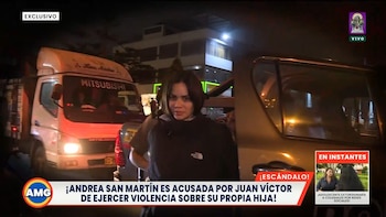 Andrea San Martín de pie de noche junto a un vehículo, con un camión detrás y rótulos informativos de televisión en la parte inferior