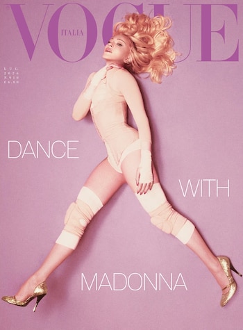 Madonna en body color piel, medias de red, rodilleras, coderas y tacones dorados, con cabello rubio rizado sobre fondo lila. Título Vogue Italia