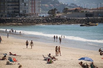 Turistas disfrutan del buen tiempo en la playa de Silgar en Sanxenxo. (Elena Fernández/Europa Press)