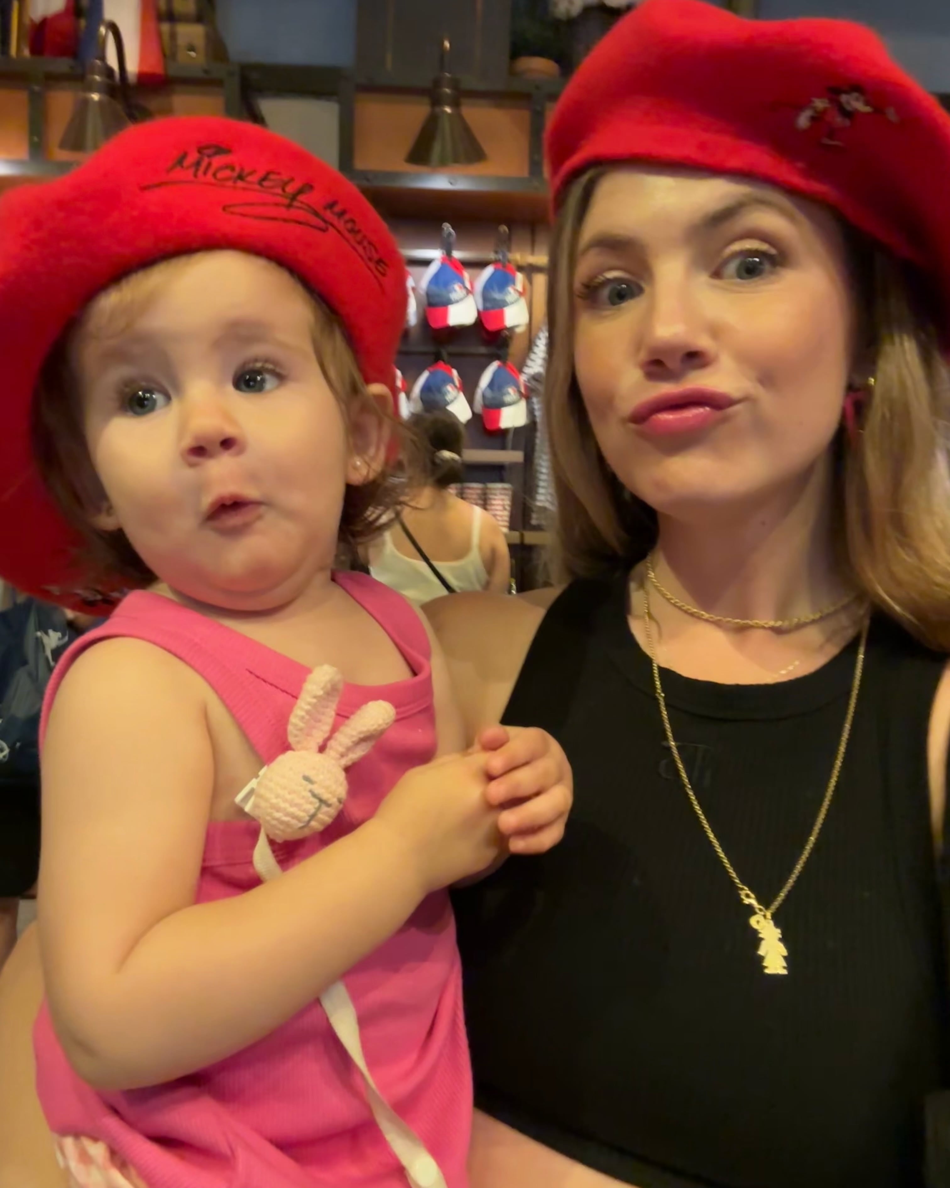 Stephanie y su hija Ariana luciendo boinas rojas con motivos de Mickey Mouse mientras posan juntas ante la cámara