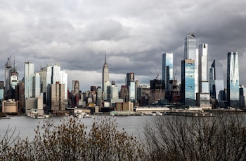 Vista panorámica del horizonte de Nueva York con múltiples rascacielos, incluyendo el Empire State Building, junto al río Hudson bajo un cielo nublado