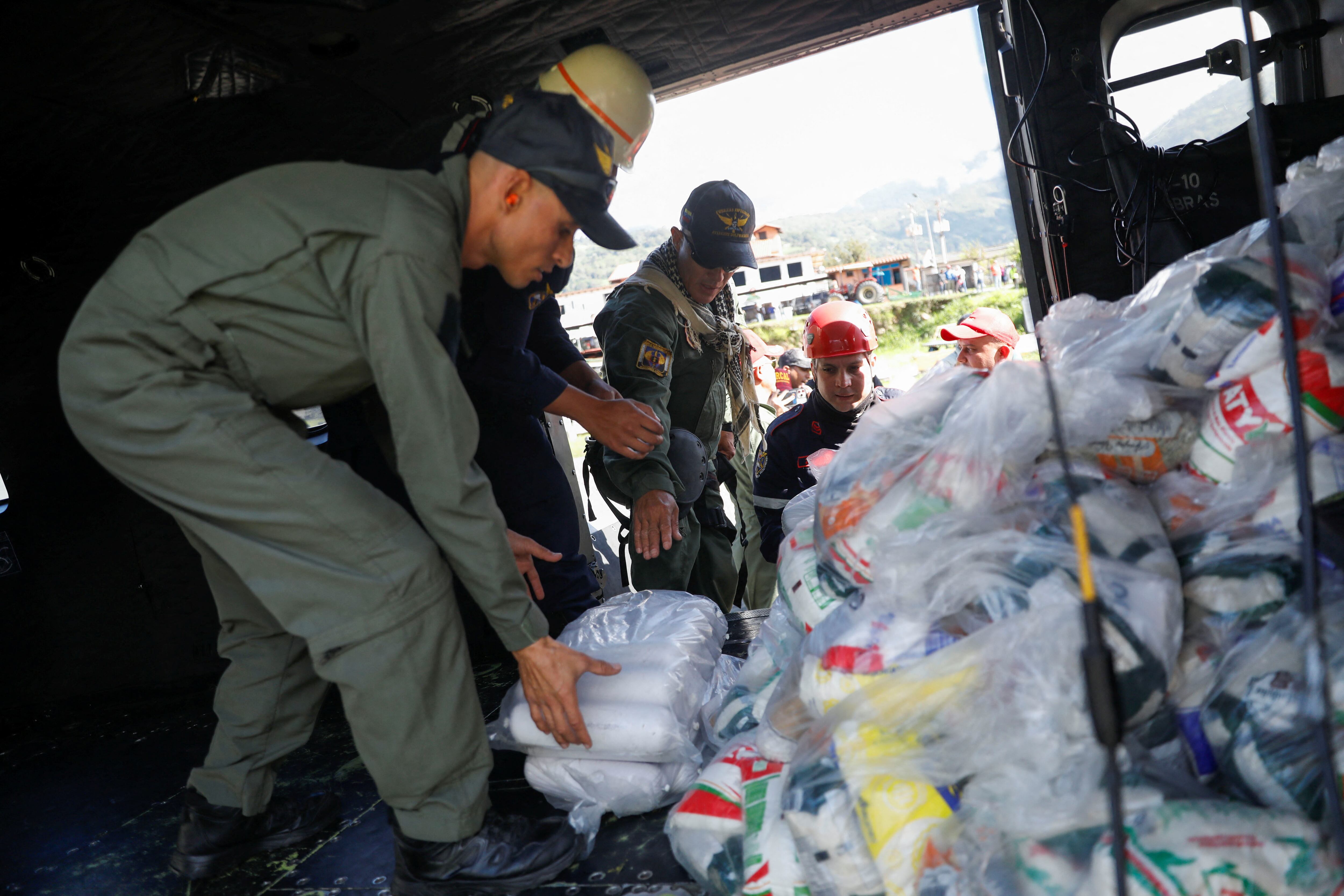 Voluntarios y autoridades cargan un helicóptero con suministros para ayudar a las comunidades afectadas por las inundaciones en Mérida, Venezuela (REUTERS/Leonardo Fernández Vilora)