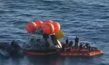 La nave Orión flota en el Pacífico, mientras los astronautas esperan a ser extraídos por personal especializado
