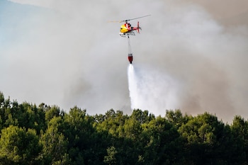 Helicóptero bombardero trabaja en las tareas de extinción del incendio en Pla de Manlleu. (Lorena Sopêna/Europa Press)