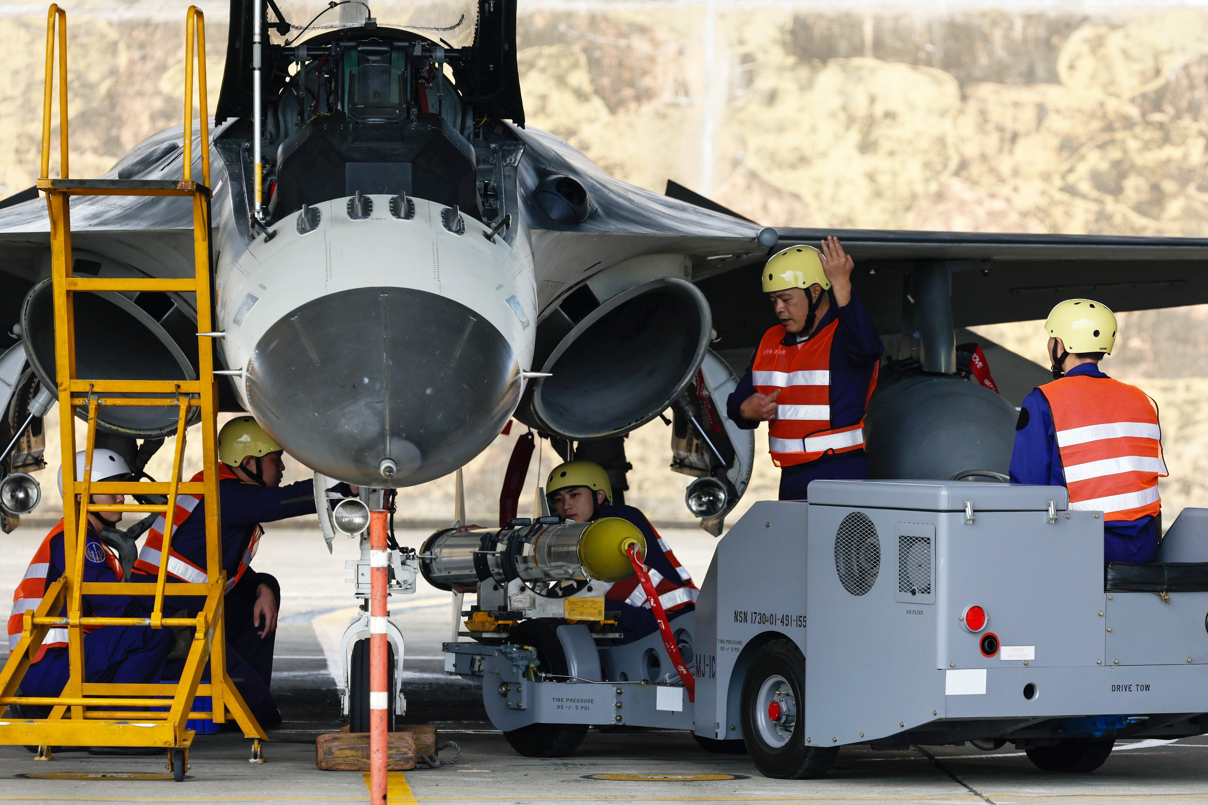 El personal de tierra de la Fuerza Aérea de Taiwán maneja misiles para armar un avión de combate de fabricación nacional (EFE/EPA/RITCHIE B. TONGO)