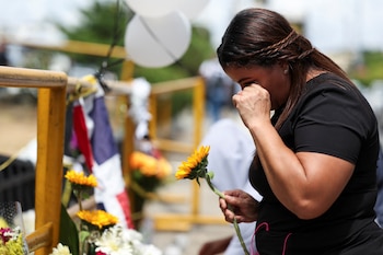 Una mujer reacciona mientras sostiene una flor, cerca del lugar del derrumbe del techo de la discoteca Jet Set, en Santo Domingo, República Dominicana, el 11 de abril de 2025. (REUTERS/Ricardo Arduengo)