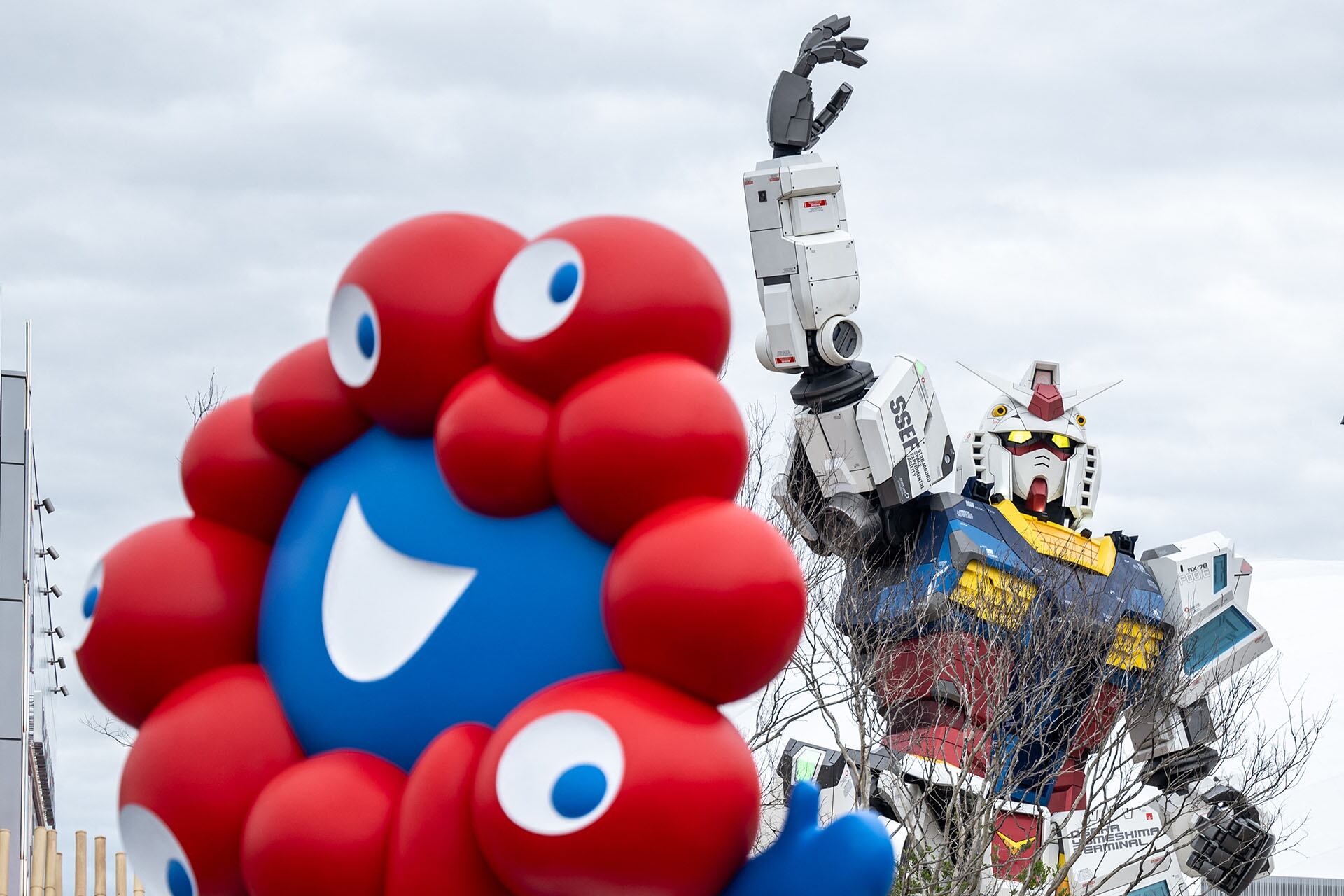 Una vista general muestra el «Myaku-Myaku», la mascota de la Expo de Osaka 2025, mientras se ve detrás el pabellón de Gundam (Philip FONG / AFP)