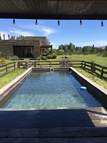 La pileta diseñada por el diseñador Bobby Rastalsky, en Puerto Panal, es un ejemplo de la integración del espejo de agua con la vivienda y el parque. Íntegramente construida de madera se fusiona con la casa en la que prepondera el mismo material