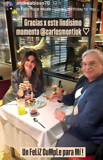 Un hombre y una mujer sentados a una mesa de restaurante sostienen copas con bebida junto a platos de postre y vasos