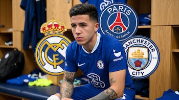 Enzo Fernández, jugador del Chelsea, sentado en un vestuario con los escudos de Real Madrid, Paris Saint-Germain y Manchester City flotando a su alrededor.