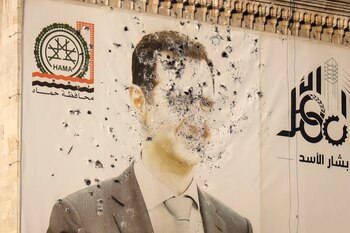 Una imagen del dictador sirio, Bashar Assad, marcada por disparos, en la oficina del gobierno provincial tras la toma de Hama por parte de la oposición rebelde (AP Foto/Omar Albam)
