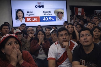Multitud de peruanos, muchos con expresiones de ansiedad, miran fijamente una pantalla que muestra resultados de ONPE: Keiko Fujimori 50.0% y Roberto Sánchez 49.9%.