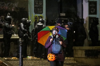 Una persona usa una máscara de gas mientras agentes de policía operan durante una protesta contra la decisión del nuevo gobierno de suspender las negociaciones de adhesión a la Unión Europea y rechazar subvenciones presupuestarias hasta 2028, en Tbilisi, Georgia, el 2 de diciembre de 2024. REUTERS/Irakli Gedenidze/Foto de archivo
