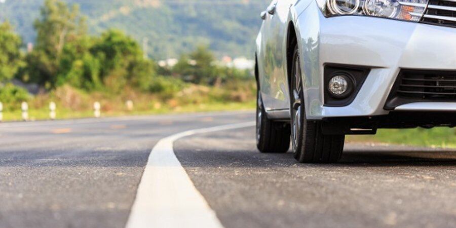Coche circulando por una carretera con línea continua (DGT)