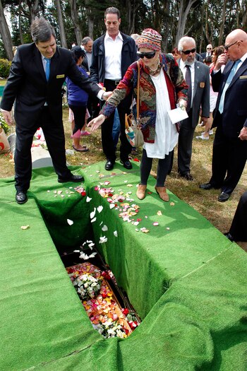 Theresa Carey, de San Francisco, deja caer pétalos en el ataúd de Miranda (AP)