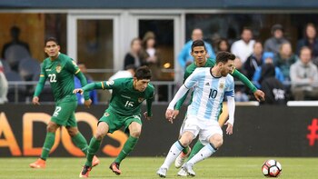 Lionel Messi ante la atenta mirada de los jugadores de Bolivia (EFE)