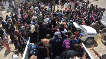 Los habitantes de Faluya se juntaron en torno a camiones que llevaban ayuda para ellos. (Reuters)