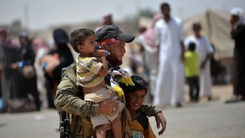 Un soldado iraquí junto a dos niños luego de haber liberado el último barrio de Faluya. (Reuters)