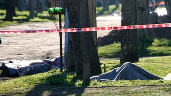 Los cadàveres del hijo mayor de Vecino y un hombre del barrio, en la escena del hecho. (Télam)