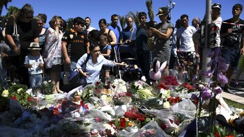 La gente lleva flores al