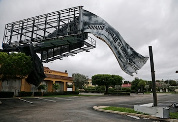 Un letrero roto ondea en el viento en North Palm Beach (AP Photo/Wilfredo Lee)