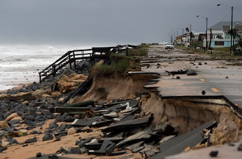 Un vehículo oficial avanza entre los escombros por la Autopista A1A, que fue arrasada por el Huracán Matthew en Flagler Beach. (AP Photo/Eric Gay)