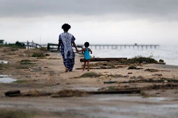 Josephine y Kira Emberton caminan entre los escombros (AP Photo/Eric Gay)
