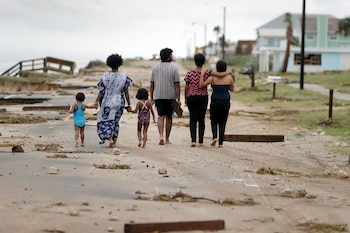 Lincoln Emberton y su familia caminan en medio de la desolación en Flagler Beach (AP Photo/Eric Gay)