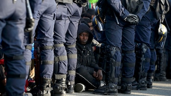 Policía francesa custodia migrantes en