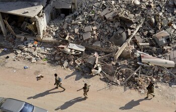 Soldados sirios caminan entre los