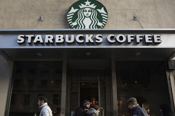 (Pedestrians walk past a Starbucks coffee shop in New York; the coffee company is targeted every holiday season for its politics. Bloomberg photo by Victor J. Blue)