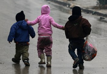 Un grupo de niños camina buscando a sus familias durante los intentos de evacuar zonas rebeldes en Siria (Reuters)