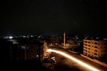 Un vehículo pasa en la noche de la ciudad Siria