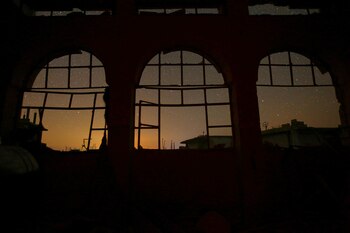 El cielo nocturno se ve a través de ventanas dañadas en la ciudad controlada por los rebeldes de Binnish en la provincia de Idlib, Siria. El 7 de septiembre de 2016