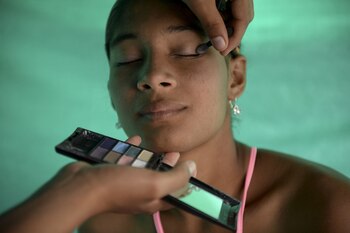 Una guerrillera es maquillada para