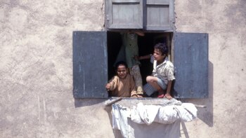 Niños se asoman en una