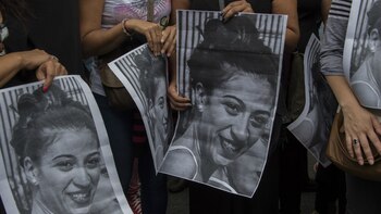 Los manifestantes sostienen pancartas de