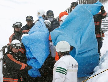 Los rescatistas con los cuerpos de algunas víctimas de la avalancha ocurrida en la ciudad de Nasu, al norte de Tokyo (Reuters)
