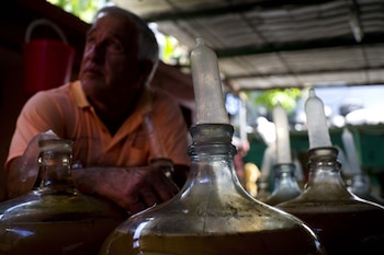 Orestes Estevez entre las botellas de vino con condones en La Habana, Cuba. (AP)