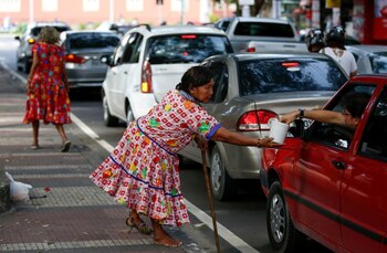Una indígena venezolana pide monedas