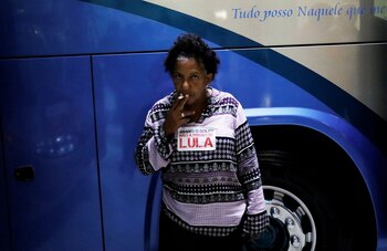 Una mujer fumaba mientras se preparaba para pasar la noche en el campamento (Reuters)