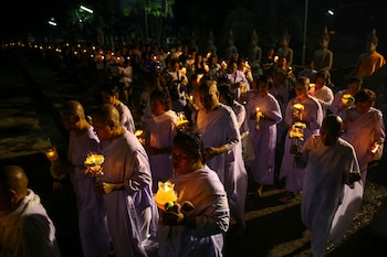 Monjas y monjes budistas cargan